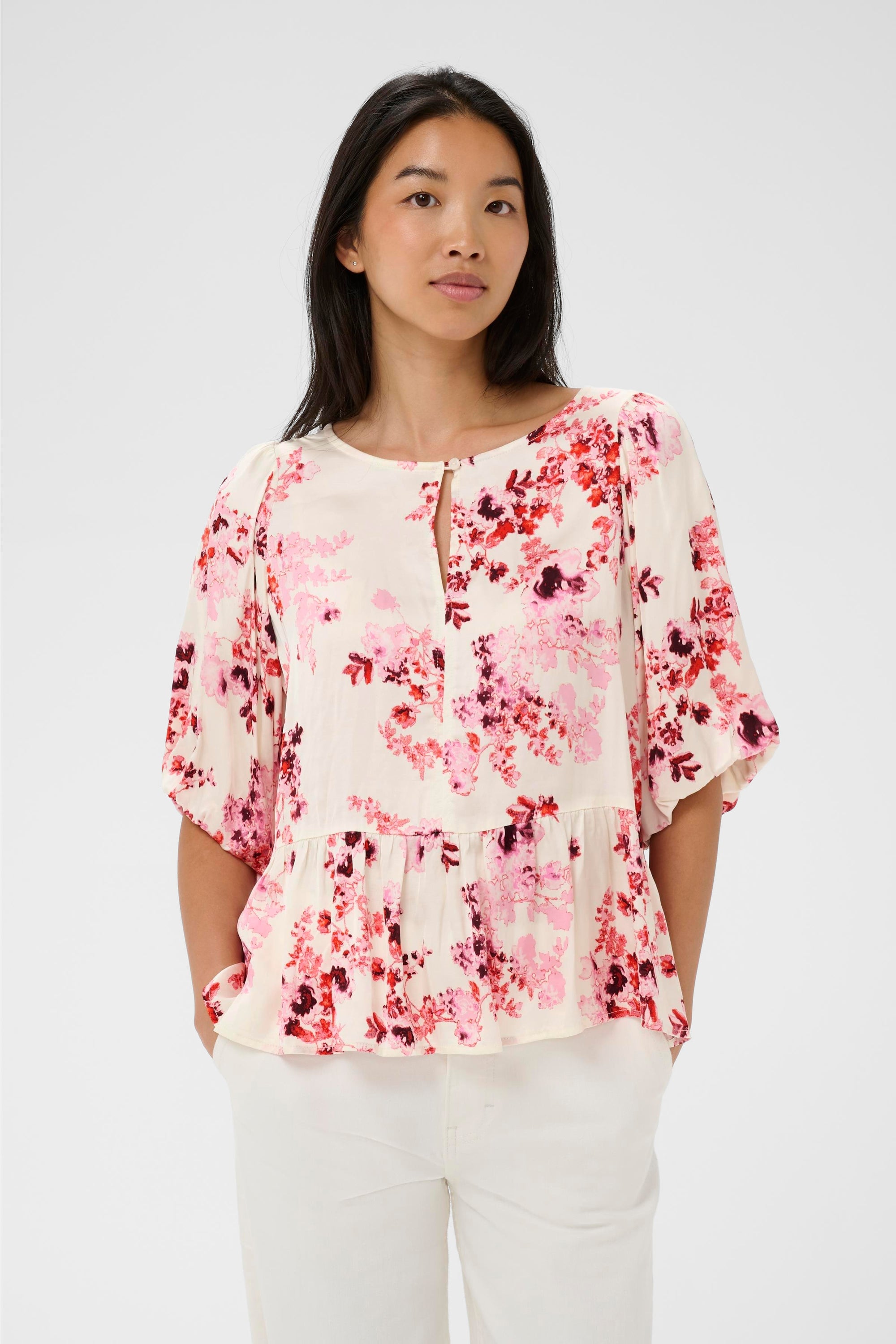 Woman wearing a floral blouse with a plain background