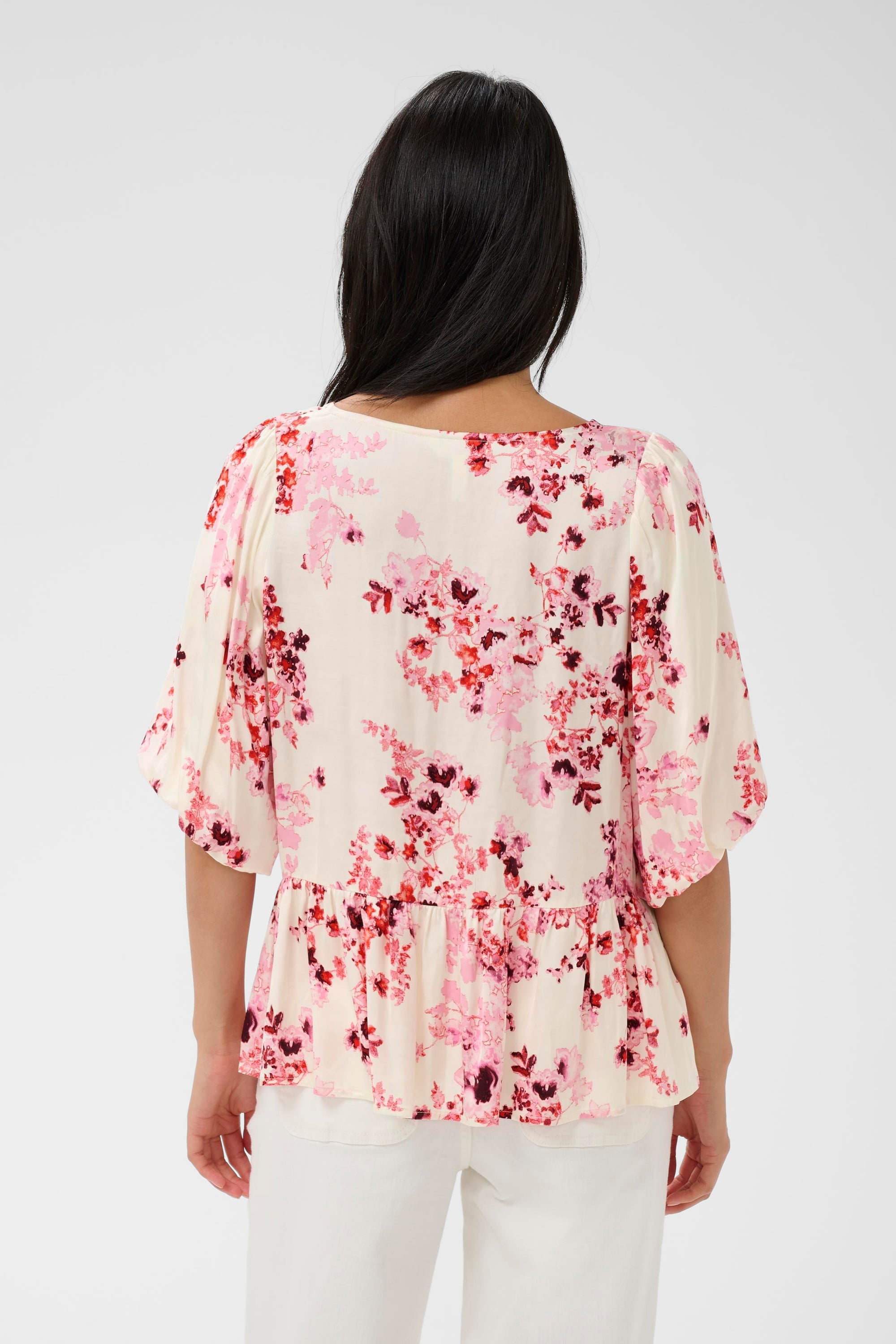 Woman wearing a floral blouse with a plain background