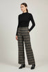 A model wearing a black long-sleeve mock neck top and a Part Two high-waisted, wide-leg plaid trousers in brown and beige tones, paired with black ankle boots, against a neutral light gray studio background.
