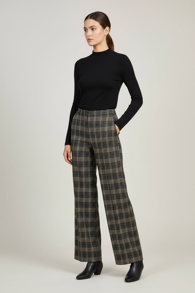 A model wearing a black long-sleeve mock neck top and a Part Two high-waisted, wide-leg plaid trousers in brown and beige tones, paired with black ankle boots, against a neutral light gray studio background.