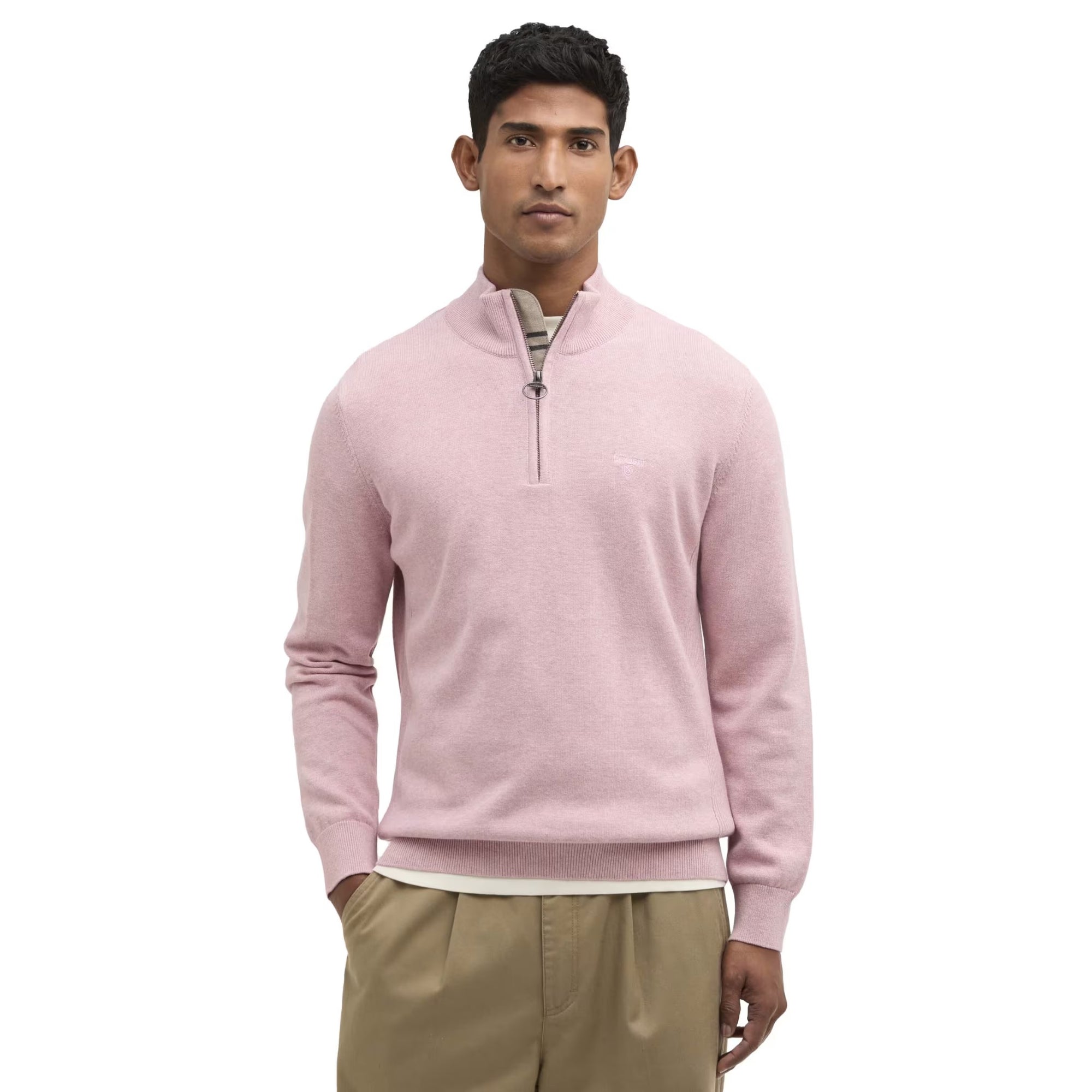 Man wearing a pink half-zip sweater and beige pants on a white background