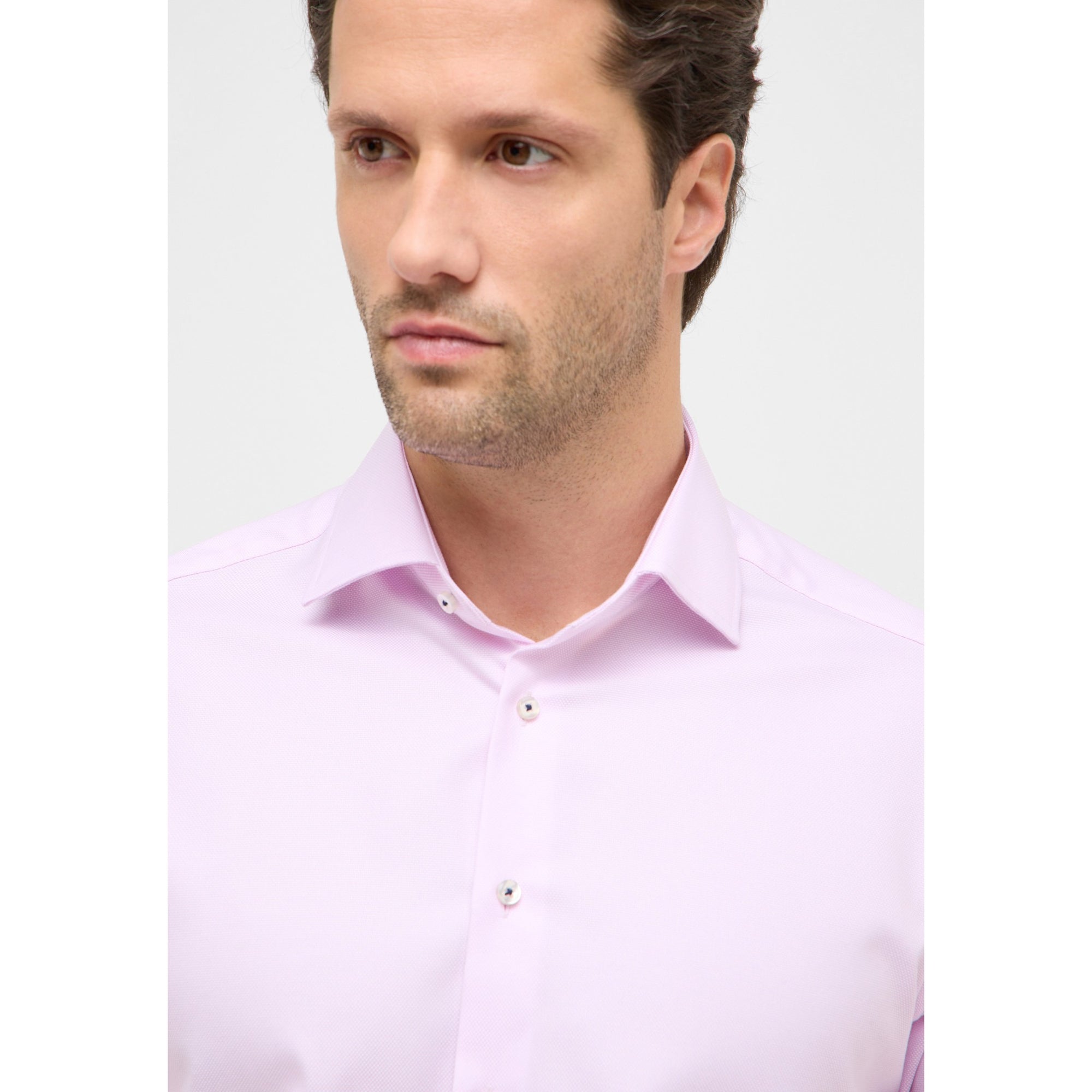 Man wearing a light purple dress shirt against a plain background