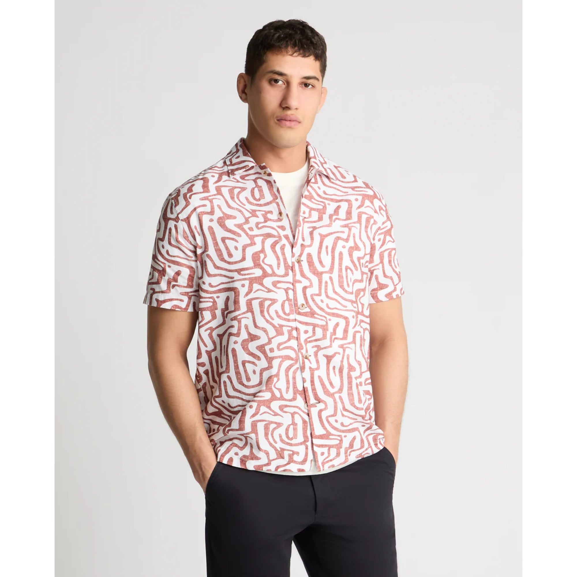 Man wearing a patterned shirt with a plain background