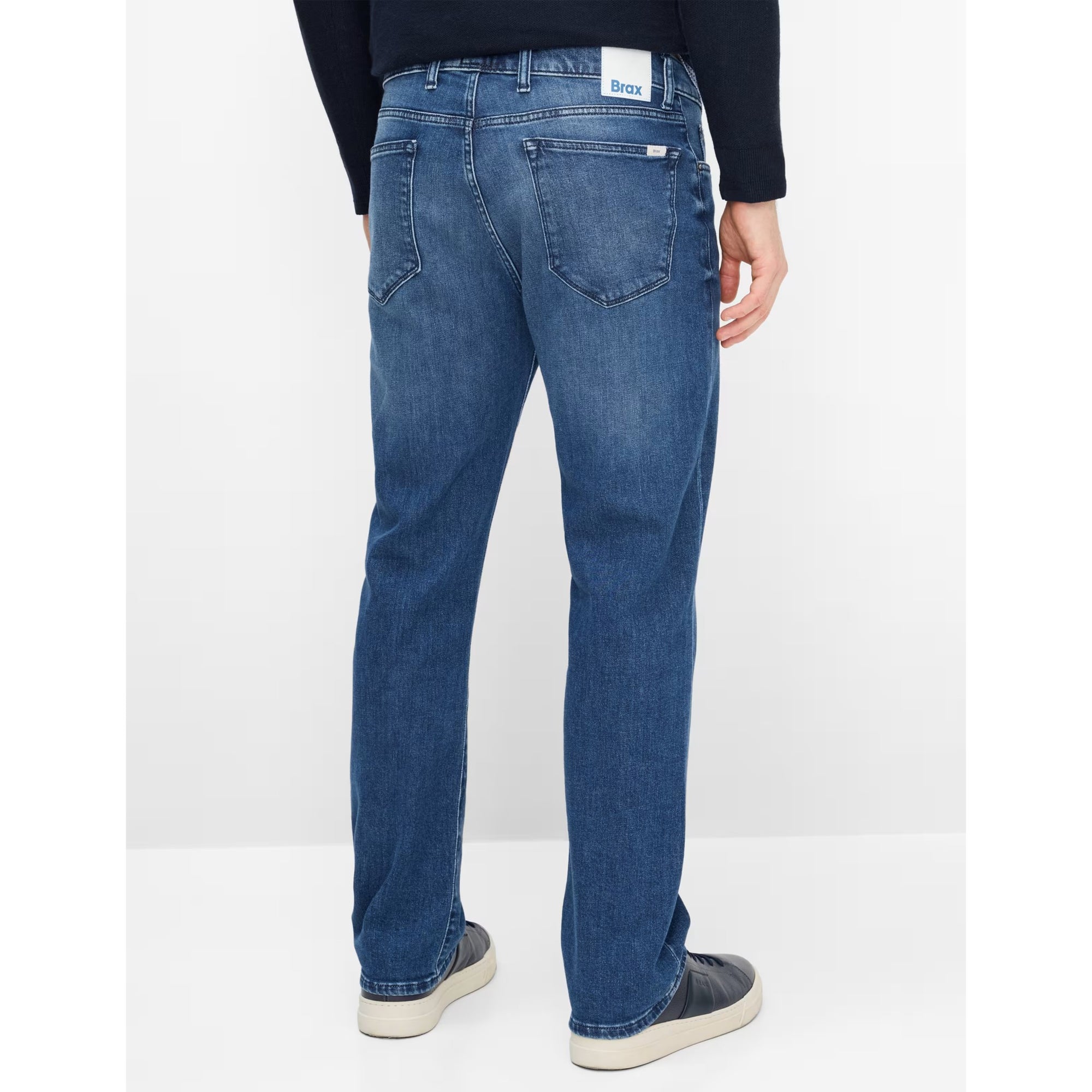Person wearing blue jeans on a white background