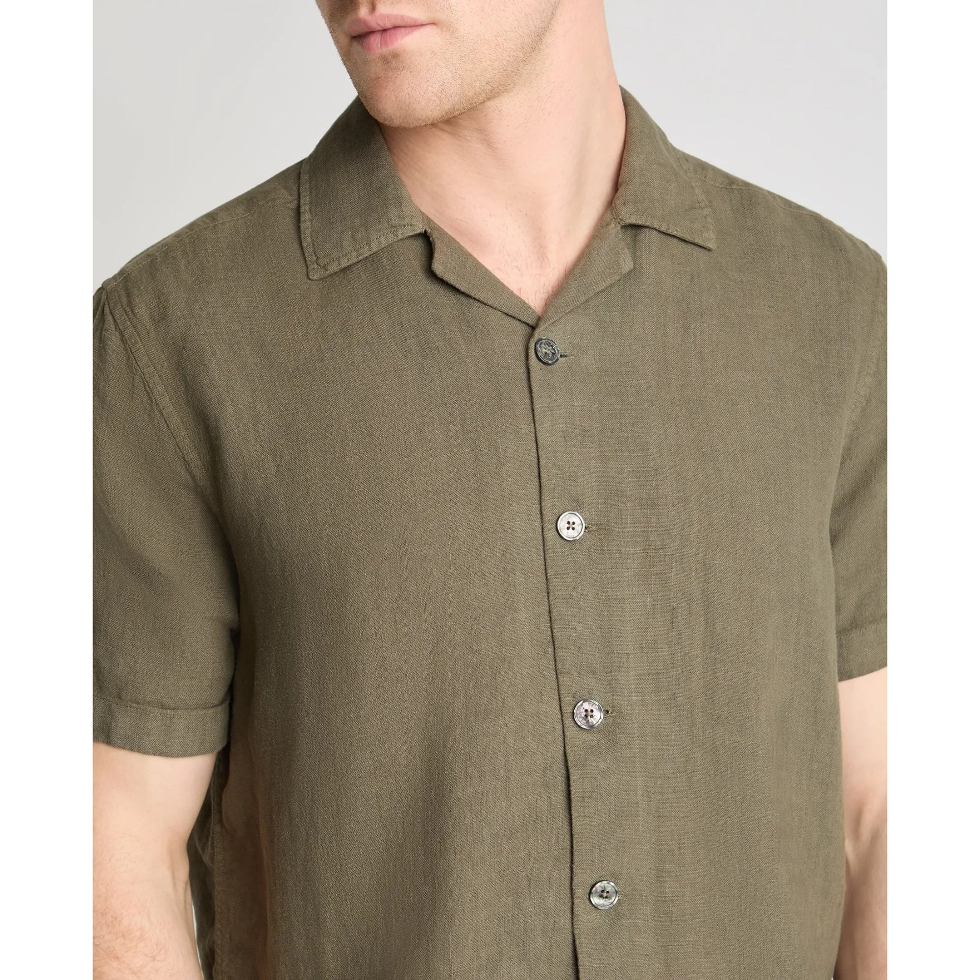 Olive green button-up shirt worn by a person on a plain background