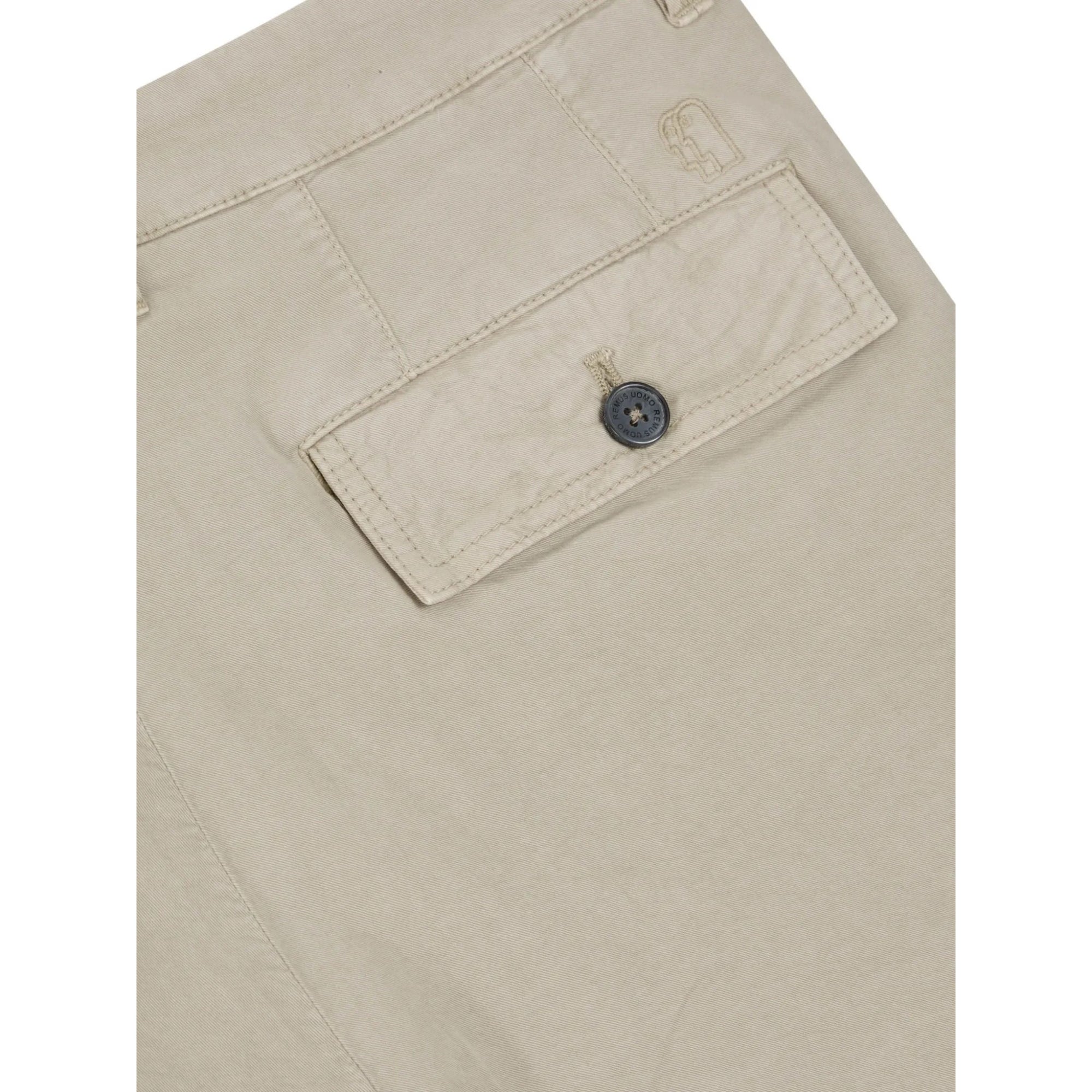 Close-up of beige pants with a button on a white background
