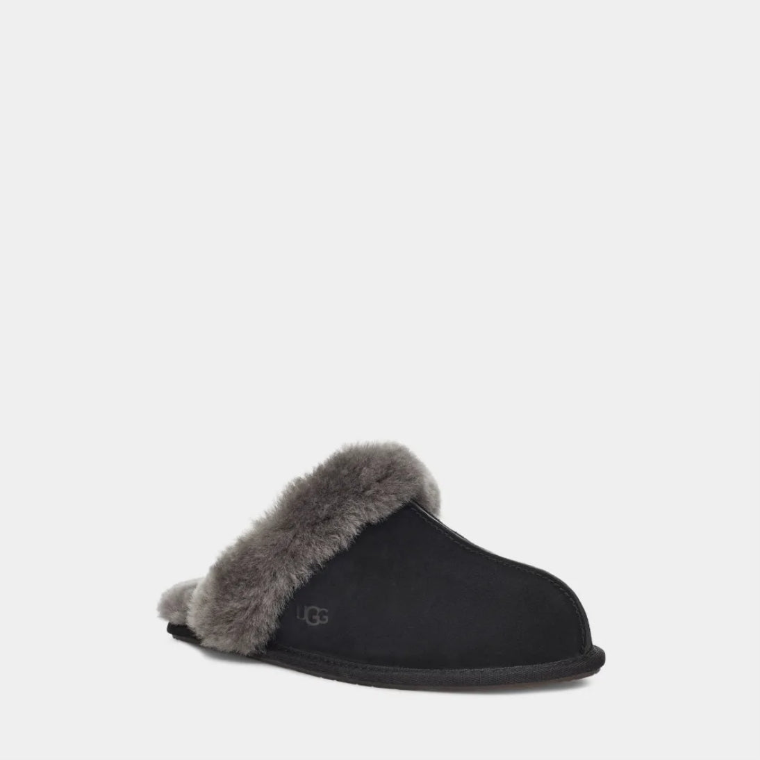 Black UGG slipper with beige fur lining on a light gray background