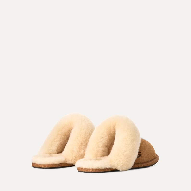 Pair of beige slippers with fur lining on a white background