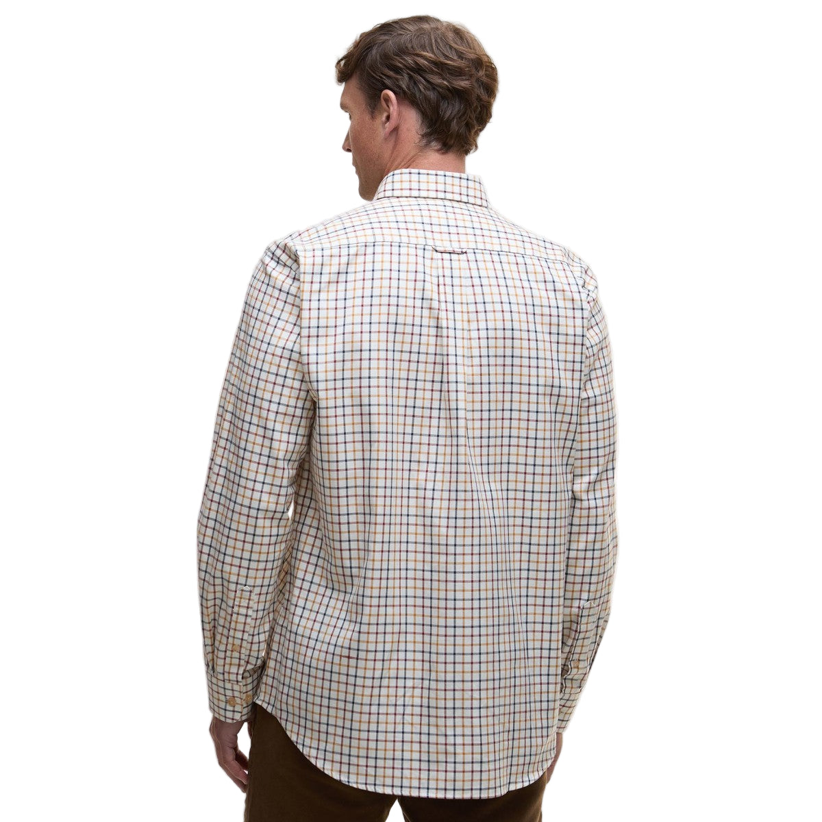 Man wearing a Barbour plaid shirt and brown pants on a white background