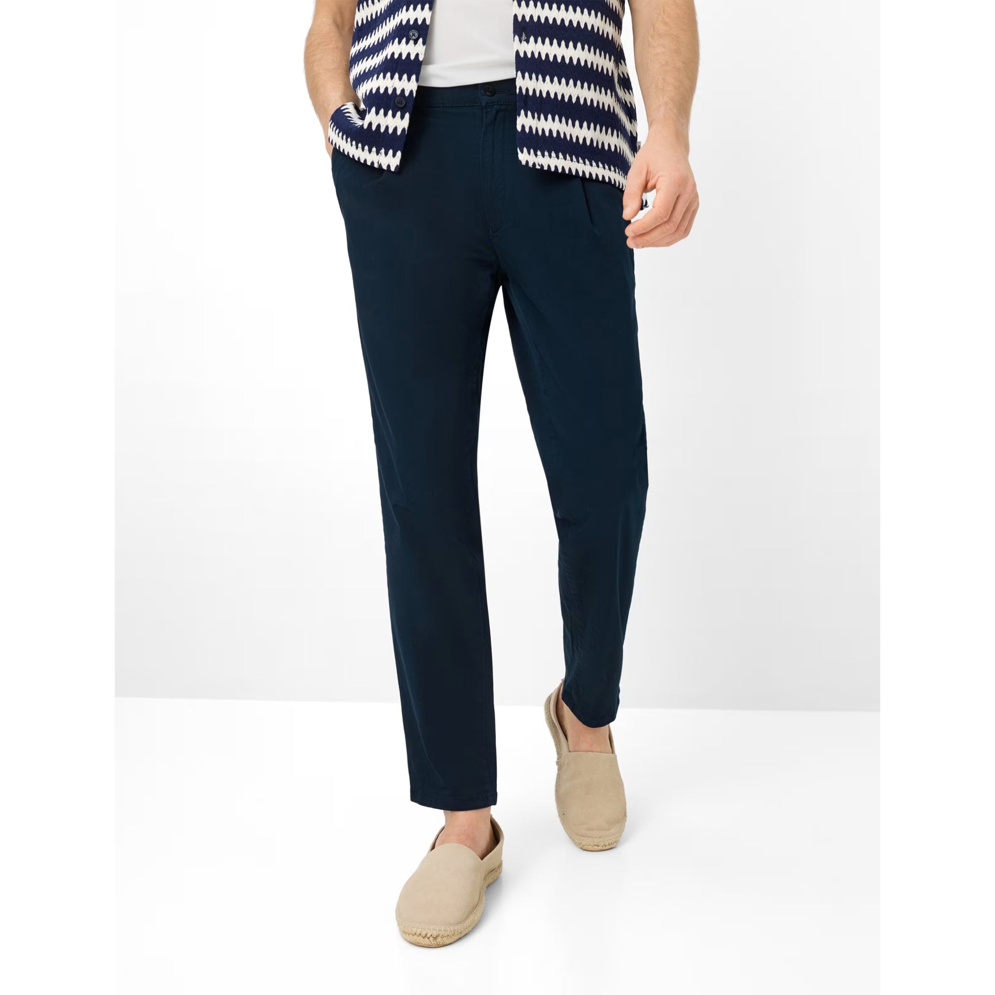 Person wearing navy pants with a white and blue striped top on a white background