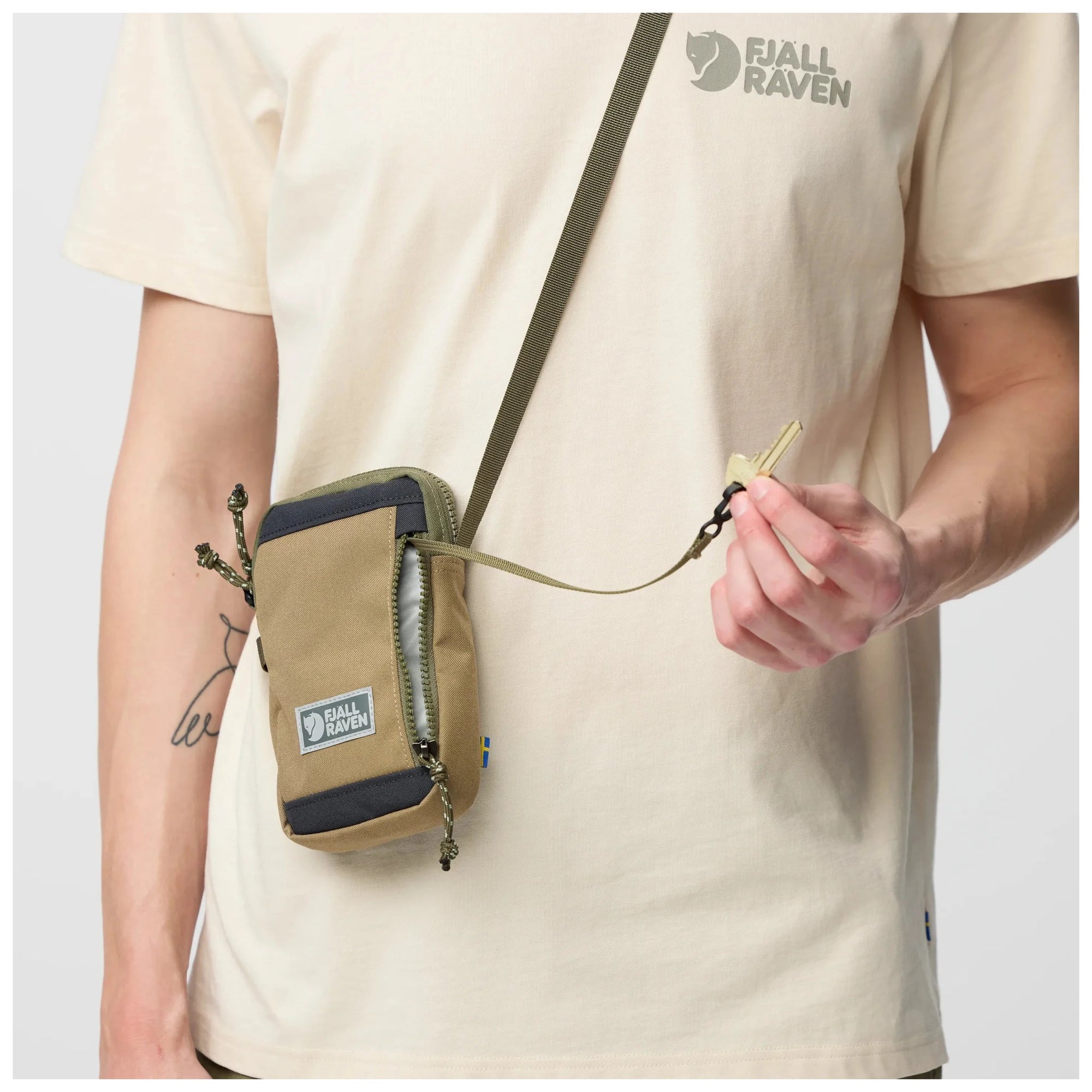 Person wearing a Green-Clay Fjäll Räven bag on a plain background