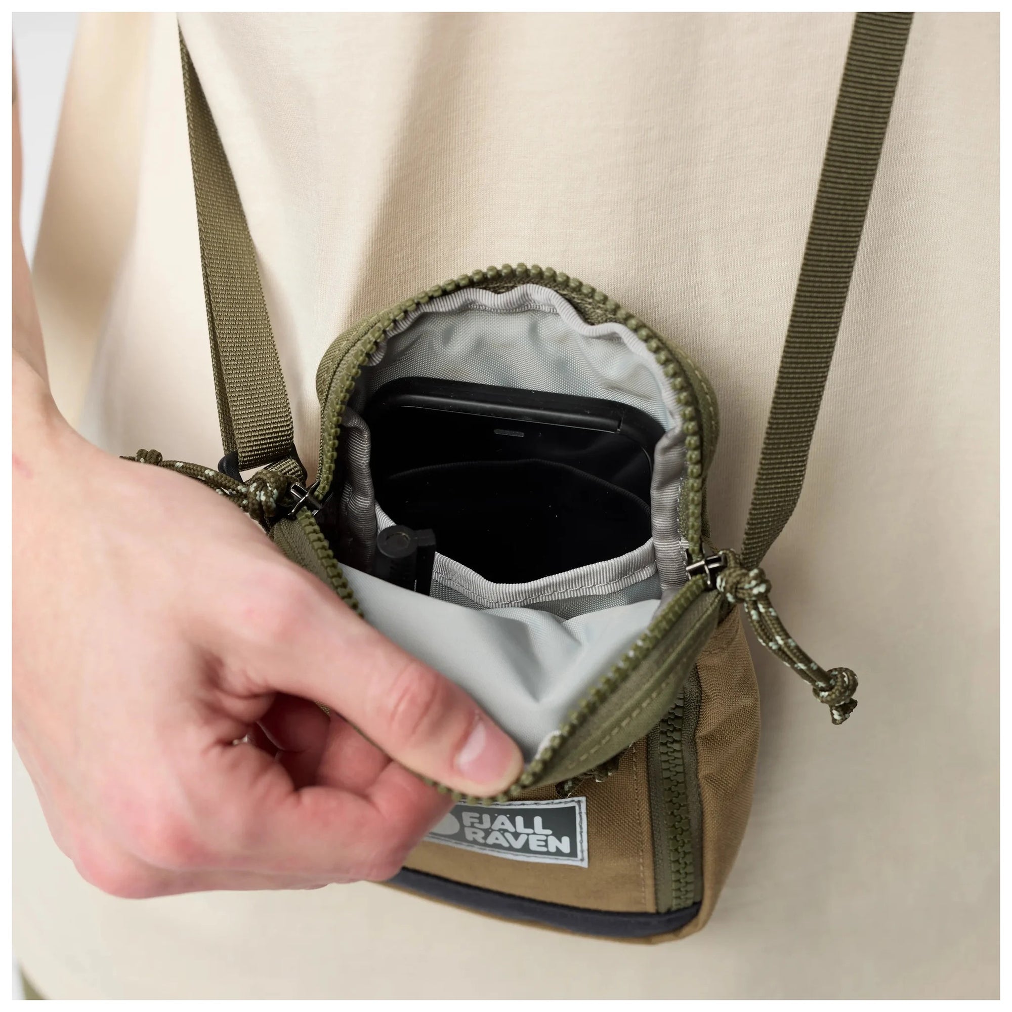 Small pouch with a hand opening it, showing its contents on a Green-Clay background.