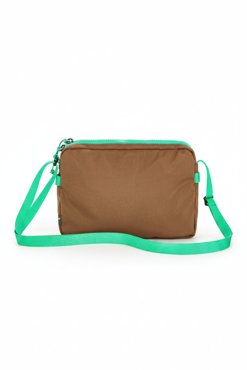 Brown bag with green strap on a white background