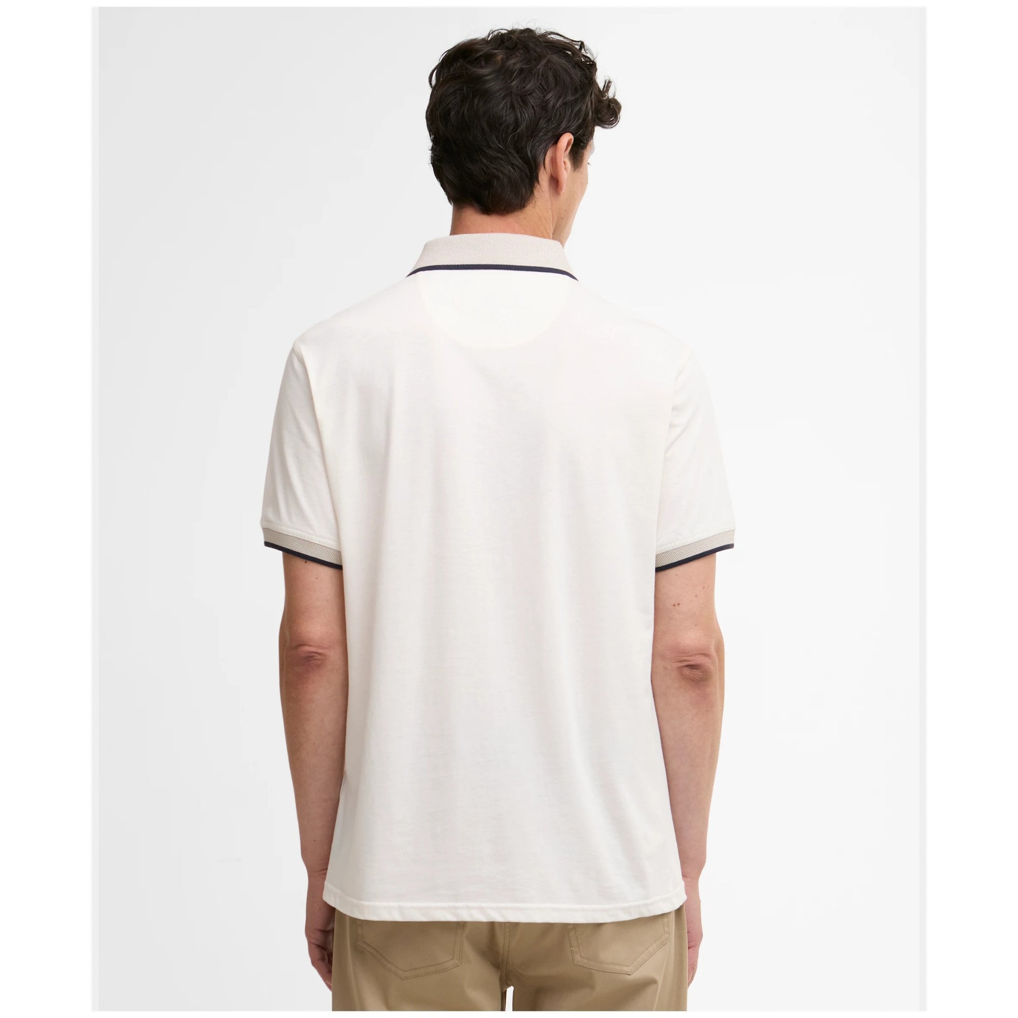 Man wearing a white polo shirt on a plain background