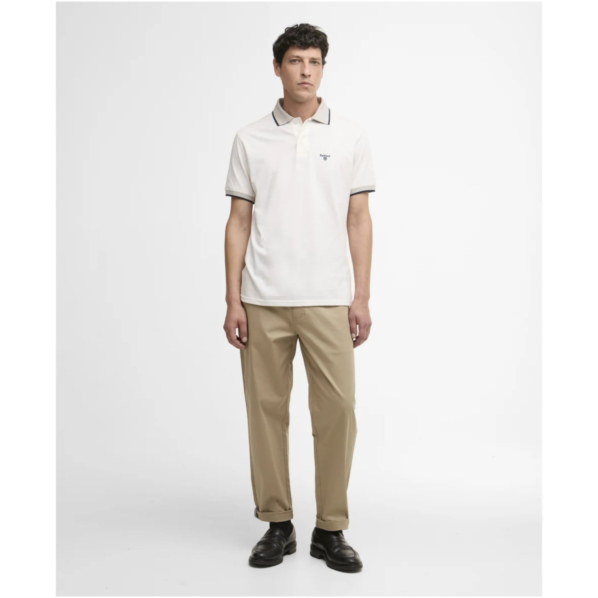 Man wearing a white polo shirt and beige pants on a white background