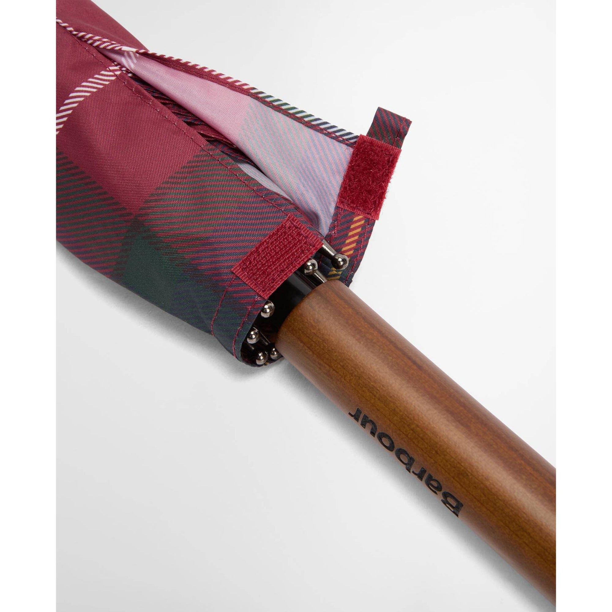 Close-up of a plaid umbrella with a wooden handle on a white background