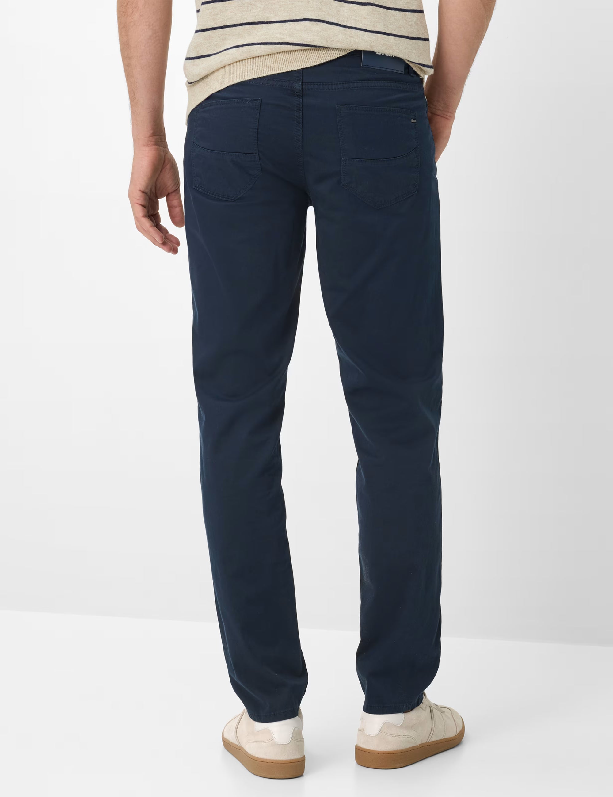 Person wearing navy blue pants on a white background