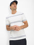 Man wearing a white t-shirt with blue stripes and a navy cap on a white background