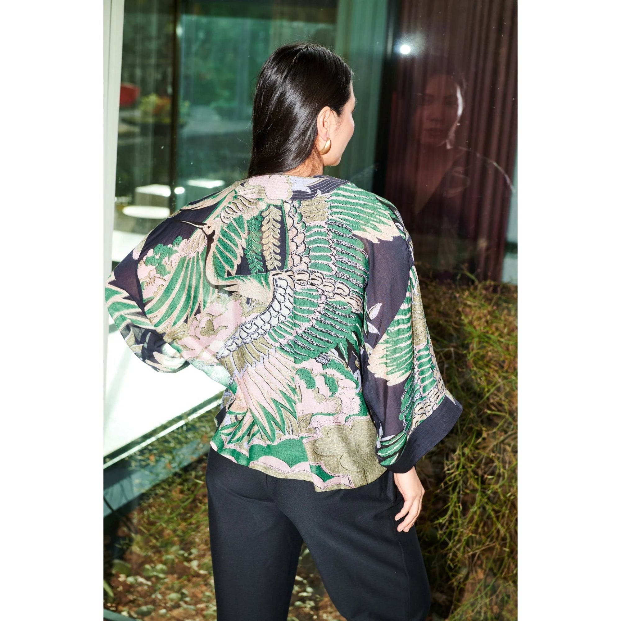 Person wearing a patterned top with a blurred background