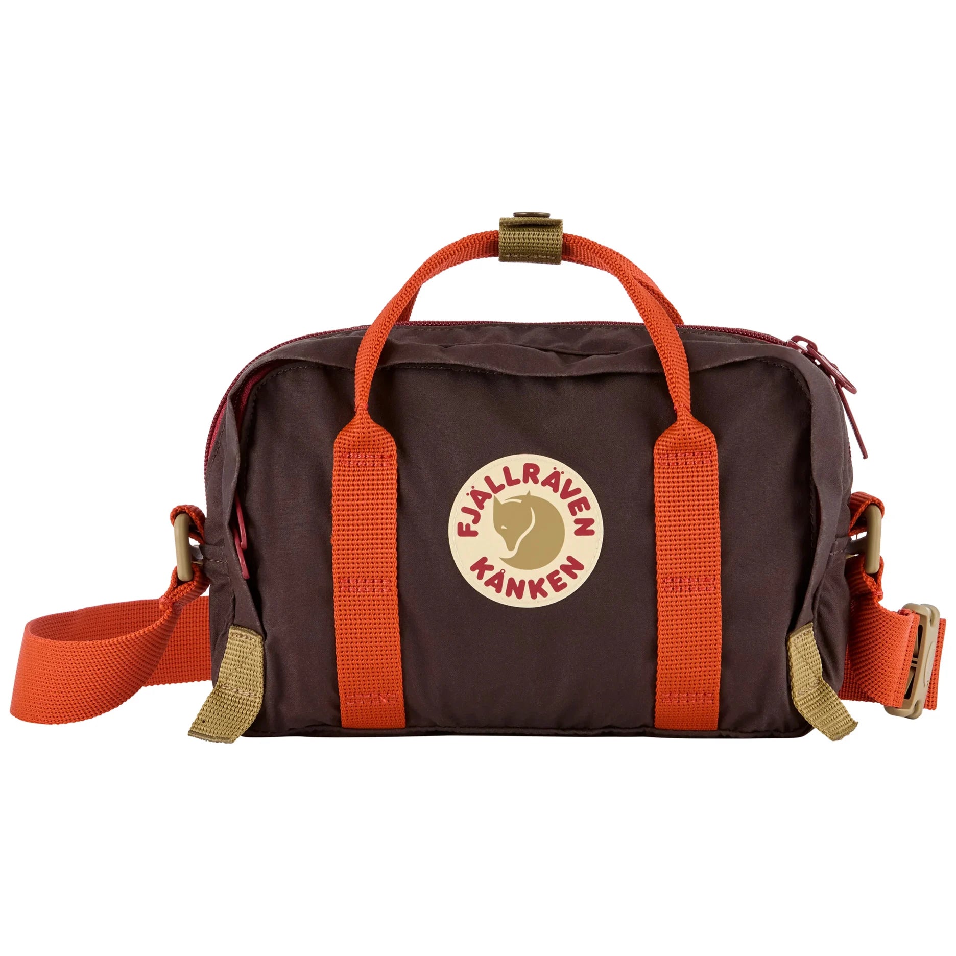 A Fjällraven Känken duffel bag in dark brown with bright orange webbing handles and strap, featuring a circular Fjällraven Känken logo patch on the front and brass-tone hardware, shown against a plain white background.