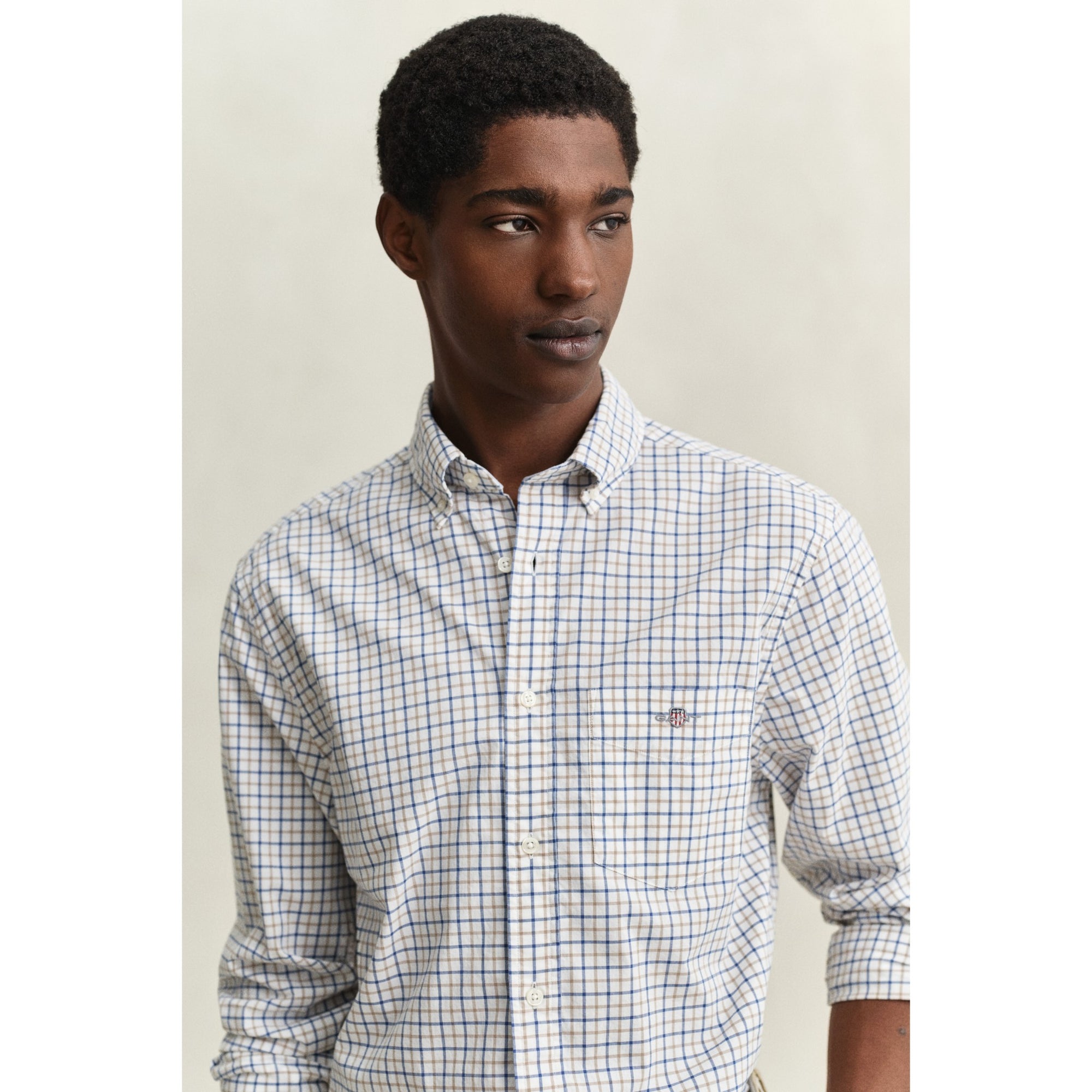 Man wearing a checkered shirt against a plain background