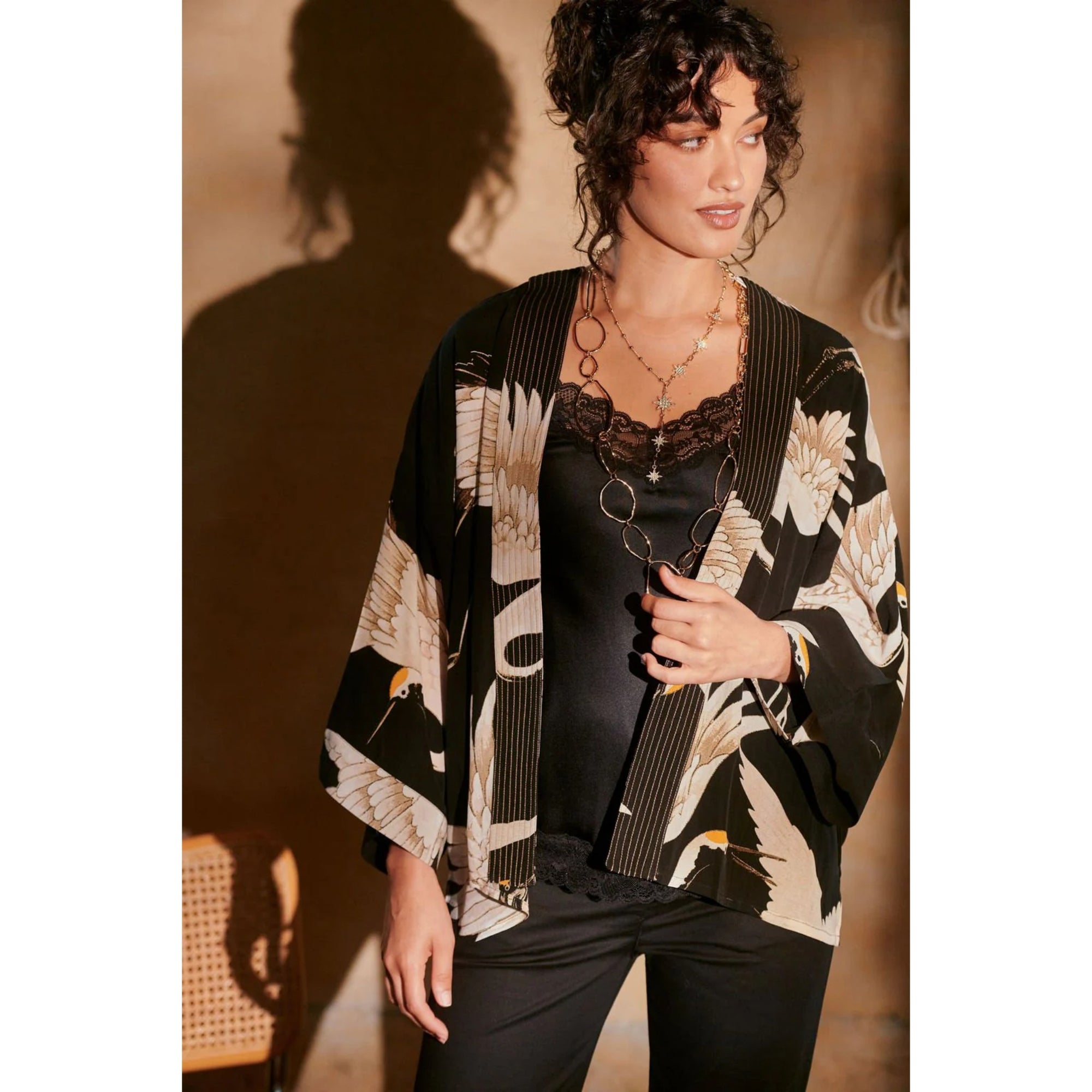 Woman wearing a black and white floral kimono against a neutral background