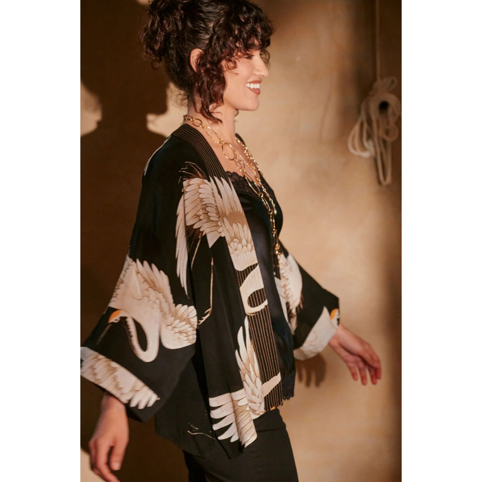 Woman wearing a black and white patterned kimono-style garment with a blurred background