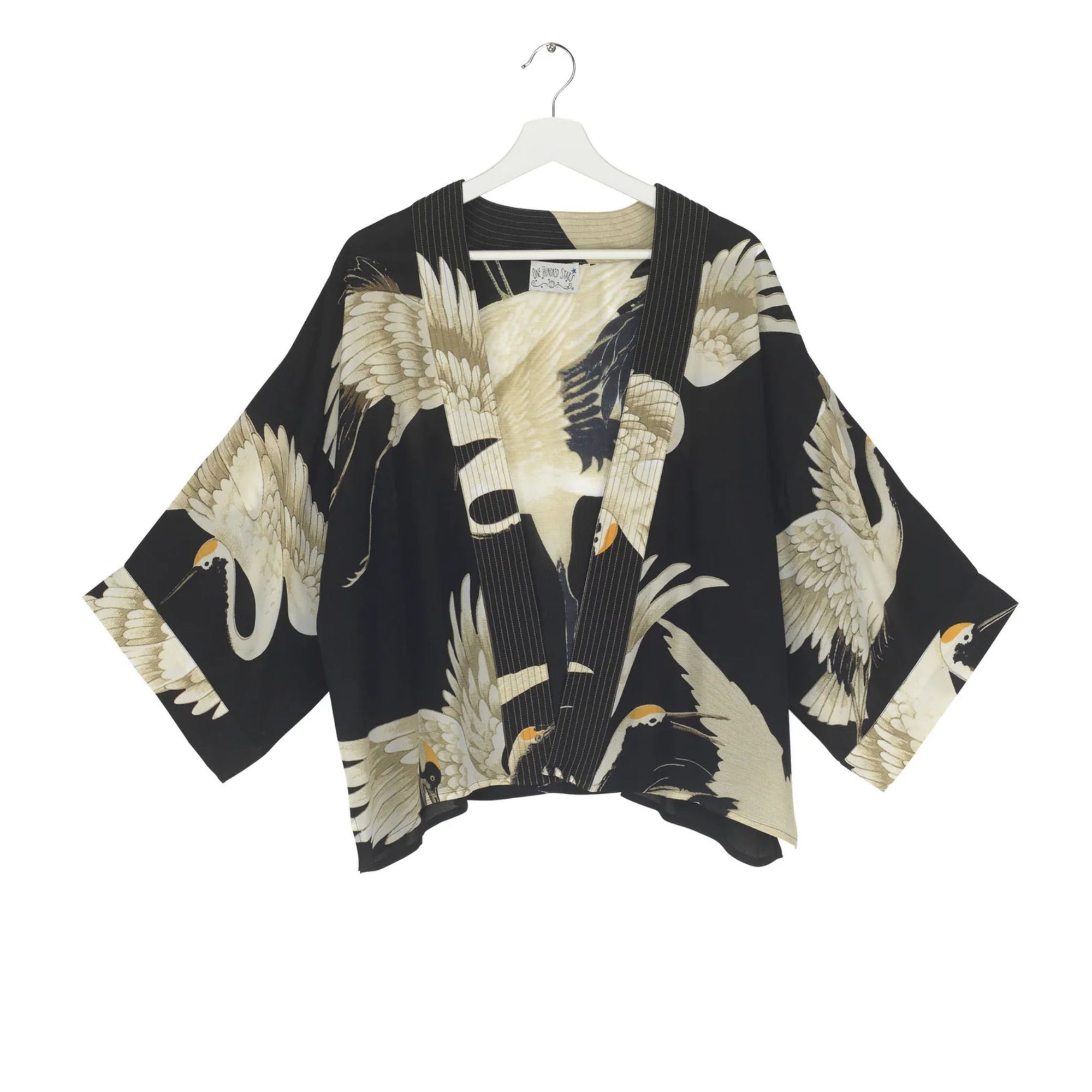 Black kimono-style garment with bird pattern on a white hanger
