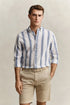 Man wearing a striped shirt and beige shorts against a plain background