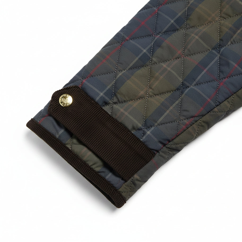 A Barbour quilted jacket in a dark blue and olive green plaid pattern, featuring a solid black corduroy collar, black front pockets, and gold-tone snap buttons.