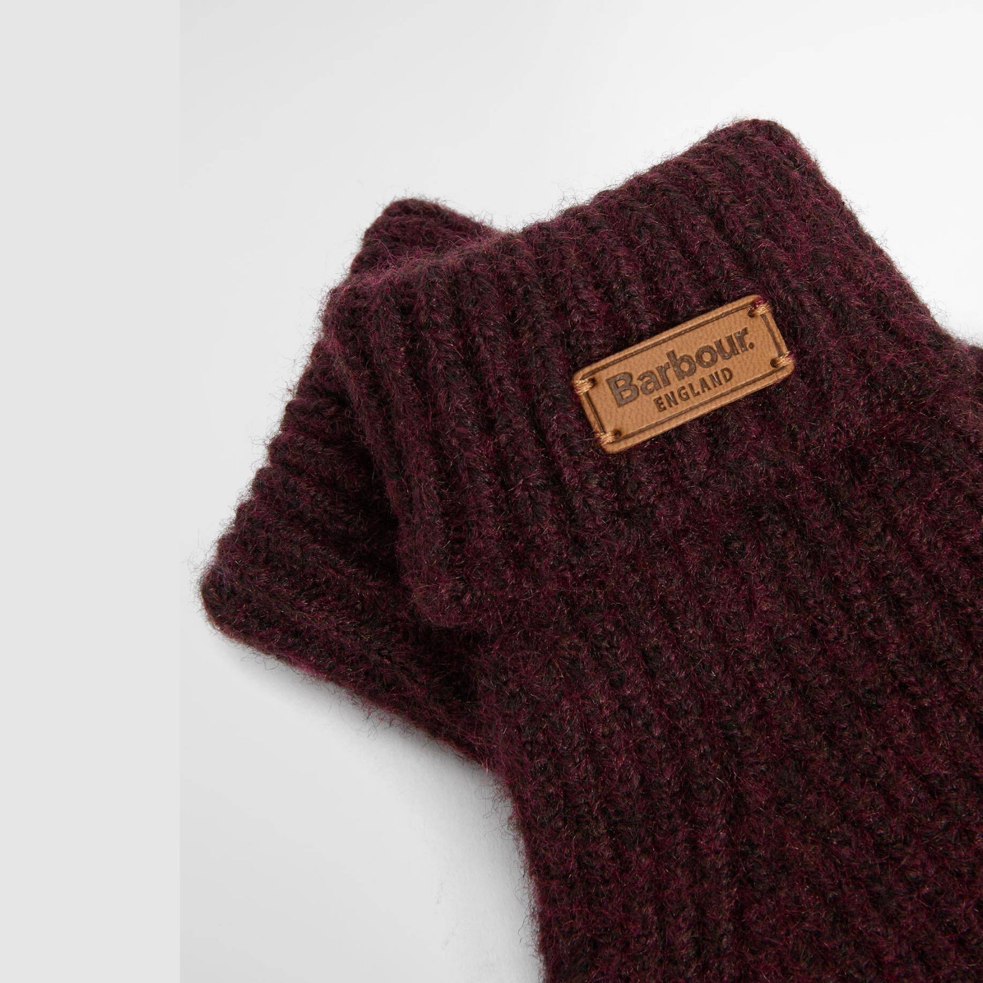 Wine knitted gloves with a Barbour England label on a white background